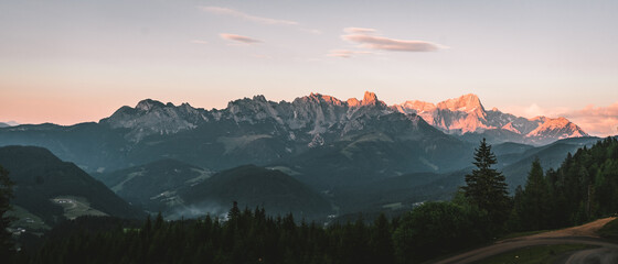 Beautiful atmospheric red morning lights between the mountain tops of the austrian dolomites