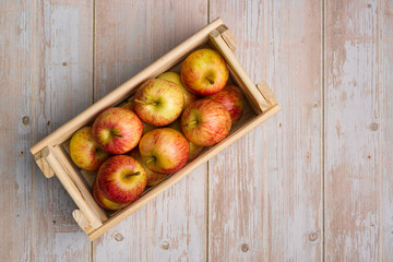 Brazilian apples in a wooden box on a wooden table.