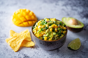 Mango Guacamole with corn chips and ingredients to prepare it
