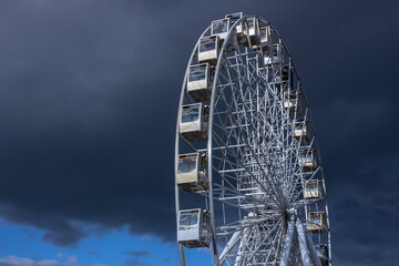 Ferris wheel on the background of dark clouds