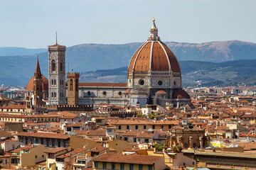 Fototapeta na wymiar Top aerial panoramic view of Florence city with Duomo Cattedrale di Santa Maria del Fiore cathedral, buildings houses with orange red tiled roofs and hills range, blue sky white clouds, Tuscany, Italy