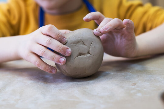 The child works with clay. The concept of a creative workshop for a child.
