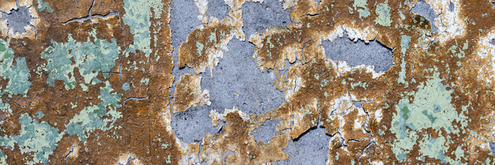 Peeling paint on the wall. Panorama of a concrete wall with old cracked flaking paint. Weathered...