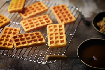 French waffles on a wire rack. Fresh hot corrugated waffles.