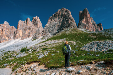 Backpacker on hiking trails in the Dolomites, Italy..View of the Three Peaks.
