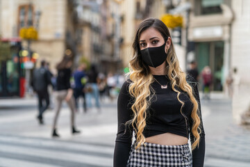 Obraz premium woman with a mask on her face, due to the coronavirus pandemic. Air, covid-19, 2019-ncov prevention