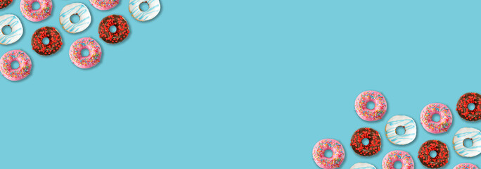 Delicious colorful donuts on blue background, flat lay. Space for text