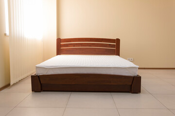 lacquered dark wooden bed with mattress
