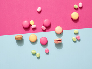 Delicious macarons with candies on a vibrant colorful background with copyspace