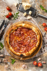 Italian pizza with jamon on a wooden board.