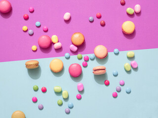Delicious macarons with candies on a vibrant colorful background with copyspace