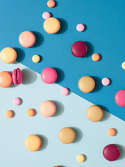 Delicious macarons with candies on a vibrant colorful background with copyspace