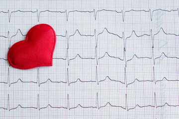 red heart on a cardiogram. top view, close-up, horizontal photo. Concept - treatment, timely...