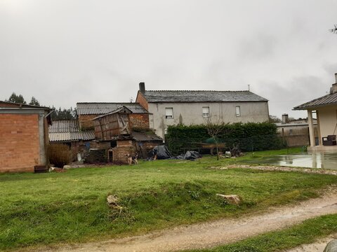 Paisaje t&iacute;pico de un entorno rural de Galicia, con un h&oacute;rreo centenario al fondo.