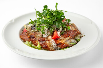 Salad of smoked eel, unagi sauce and greens with vegetables. Banquet festive dishes. Gourmet restaurant menu. White background.