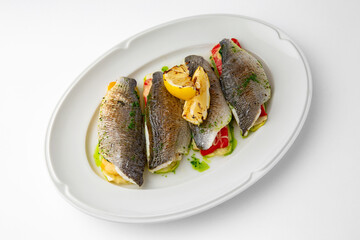 Dorada stuffed with vegetables, baked in the oven with cheese. Banquet festive dishes. Gourmet restaurant menu. White background. 
