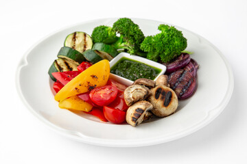 Appetizer of grilled vegetables from zucchini, eggplants, tomatoes, sweet peppers, onions. Rolls stuffed with cheese. Banquet festive dishes. Gourmet restaurant menu. White background.