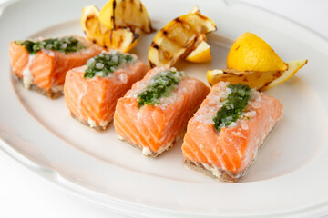 Large pieces of fillet baked with salmon cheese and sauce. Banquet festive dishes. Gourmet restaurant menu. White background.