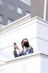 Woman with face mask using a smartphone