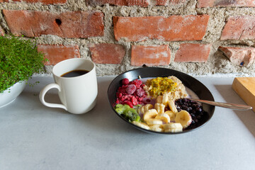 Oatmeal breakfast with raspberry, bluberries, banana, kiwi and passionfruit