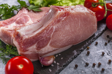 Raw pork steak with tomatoes and herbs.