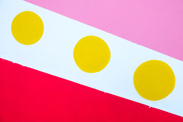 Three yellow dots on white background with pink and red patches.