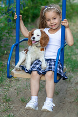Girl riding on a swing with her favorite dog