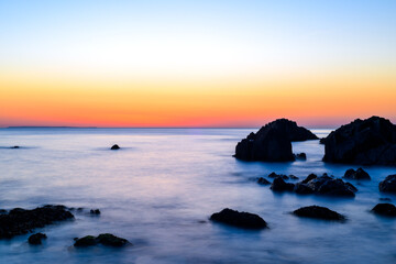 Fototapeta na wymiar Beautiful calm sea and sunset scenery on the ocean as light reflects on the water