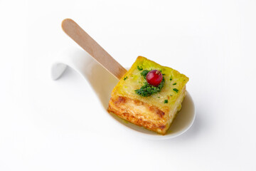 A portion of zucchini in batter with pesto sauce and currants. Beautifully decorated catering banquet menu. Food snacks and appetizers for buffet. Isolated on white background