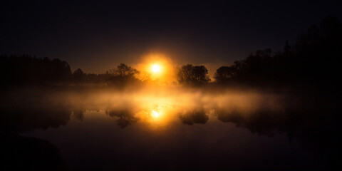 A beautiful river morning with mist and sun light. Springtime scenery of river banks in Northern Europe. Warm, colorful look.