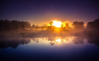 A beautiful river morning with mist and sun light. Springtime scenery of river banks in Northern Europe. Warm, colorful look.