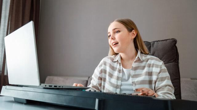 Woman learns music singing vocals playing piano online using laptop at home interior. Teenager girl sings song play piano synthesizer during video call, online lesson with teacher. Long web banner