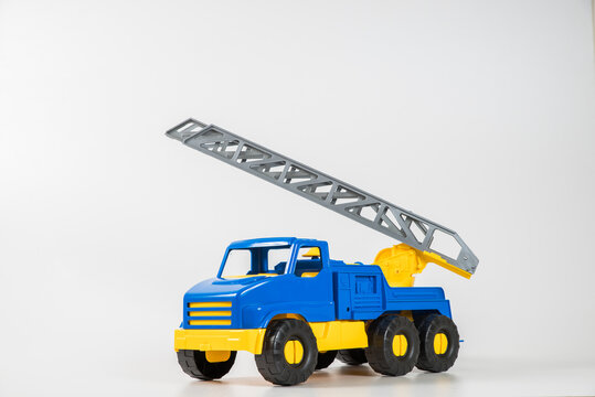 Plastic car. Toy model isolated on a white background. Yellow-blue truck with fire escape.