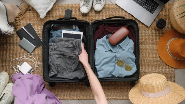Man packing suitcase for travel vacation in new normal, top view.