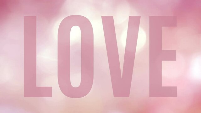 Large translucent word Love on a beautiful animation of twinkling lights in bokeh. Soft pink and light yellow sequence in a seamless loop for e-card, celebration, invitation or titling...