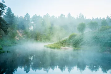 Keuken foto achterwand Mistig bos A beautiful spring landscape of a river valley with morning mist. Springtime scenery of a river flowing through the forest. Water evaporating in sun rays. Springtime scenery of Northern Europe.