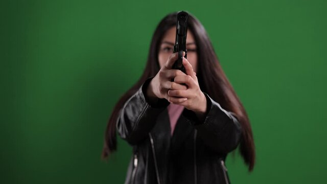 Female agent with a gun in her hands - studio shooting