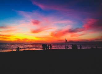 Colorful sunset on dark beach shore