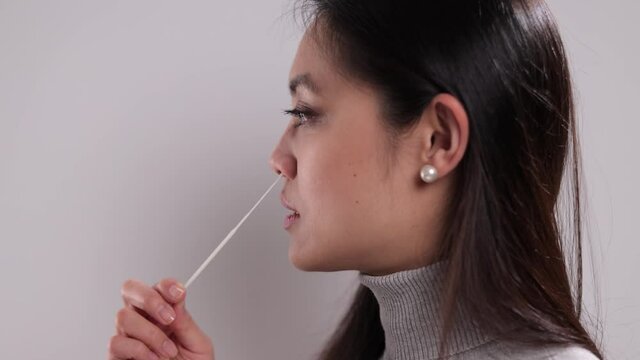 Young woman performs a Covid-19 antigen self-test - studio shooting