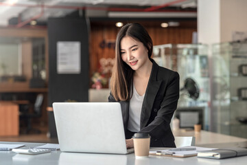 Asian businesswoman sitting work on a laptop at the office.