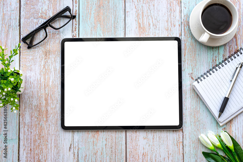 Poster top view of space creative working table wooden and tablet blank white screen is placed. mock up.