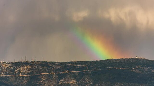 TimeLapse of RainBow moving on the edge of mountain.