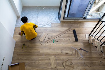 The technicians are installing laminate flooring in the room.