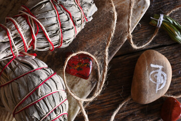 A close up image of two white sage smudge bundles and reiki healing symbol on a dark wooden table...