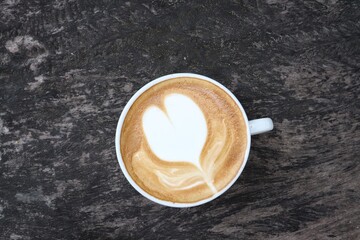 Coffee latte art milk foam and cup on wood background