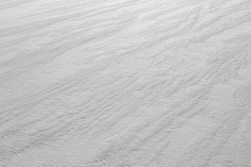 Faint parallel line patterns in pure windswept white snow