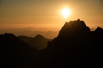 Misty sunset with beautiful silhouette of mountain range in Switzerland