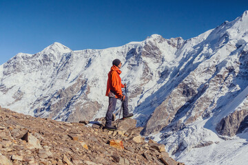 Beautiful landscape with mountains, blue huge glacier and a middle-aged mountaineer man against the background of mountains, glacier