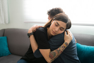 Beautiful couple hugging on the couch after missing each other