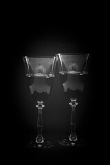 Two glasses of red wine low key in black and white